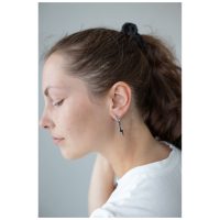 Frau mit schwarzem Zopf trägt Little Flash Hoops Ohrringe aus Chirurgenstahl