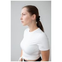 Frau mit Little 5 Rings Hoops Ohrringen in Schwarz und Silber vor grauem Hintergrund