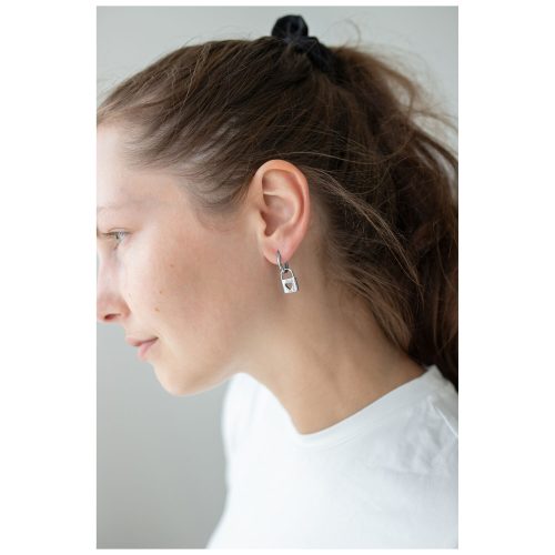 Frau trägt silberne Little Lock Hoops Ohrringe vor weißem Hintergrund