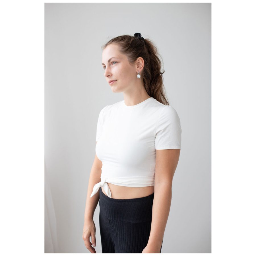 Frau in weißem T-Shirt trägt Little White Smiley Hoops vor weißem Hintergrund