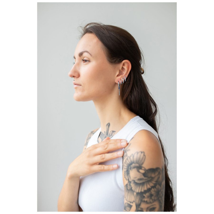 Frau mit langen Haaren trägt Little Square Crystal Hoops in Silber