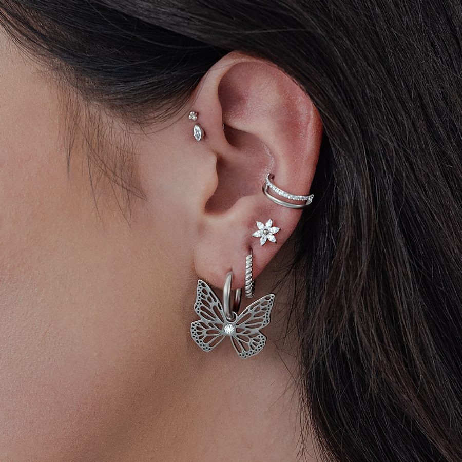 Silberne Little Butterfly Hoops Ohrringe am Ohr einer Frau, mit weiteren Ohrsteckern