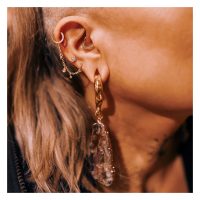 Ohr mit goldener Piercingkette und Kristalltropfen, Detailansicht