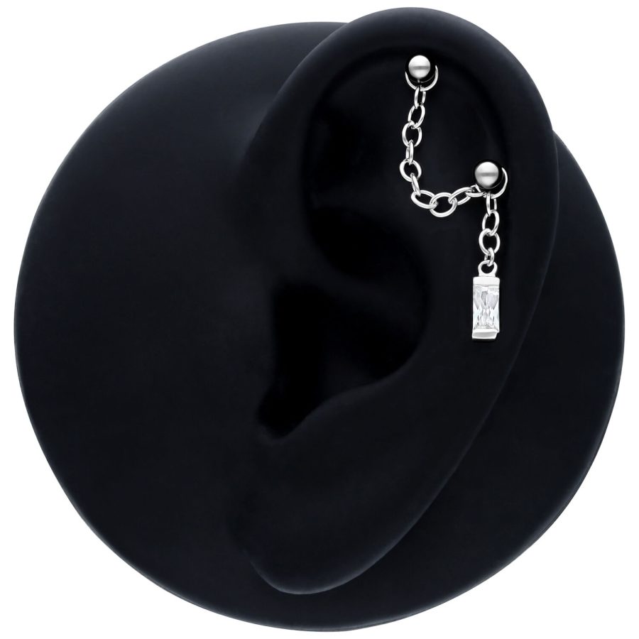 Schwarze Piercingkette mit Hänge-Baguette-Kristall an einem Ohrmodell