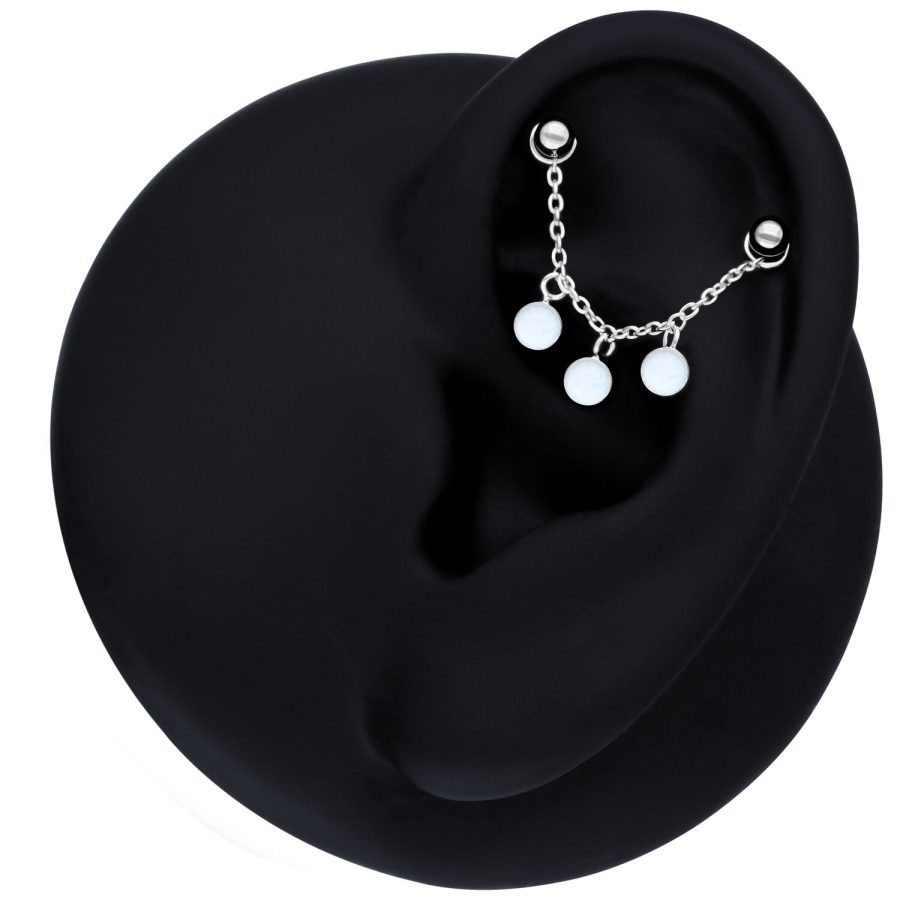 Schwarze Piercingkette mit synthetischem Opal am Ohr auf schwarzem Hintergrund