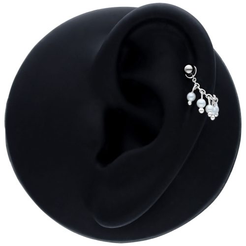 Schwarze Piercingkette mit kleinen Perlen an einem Ohr auf schwarzem Hintergrund
