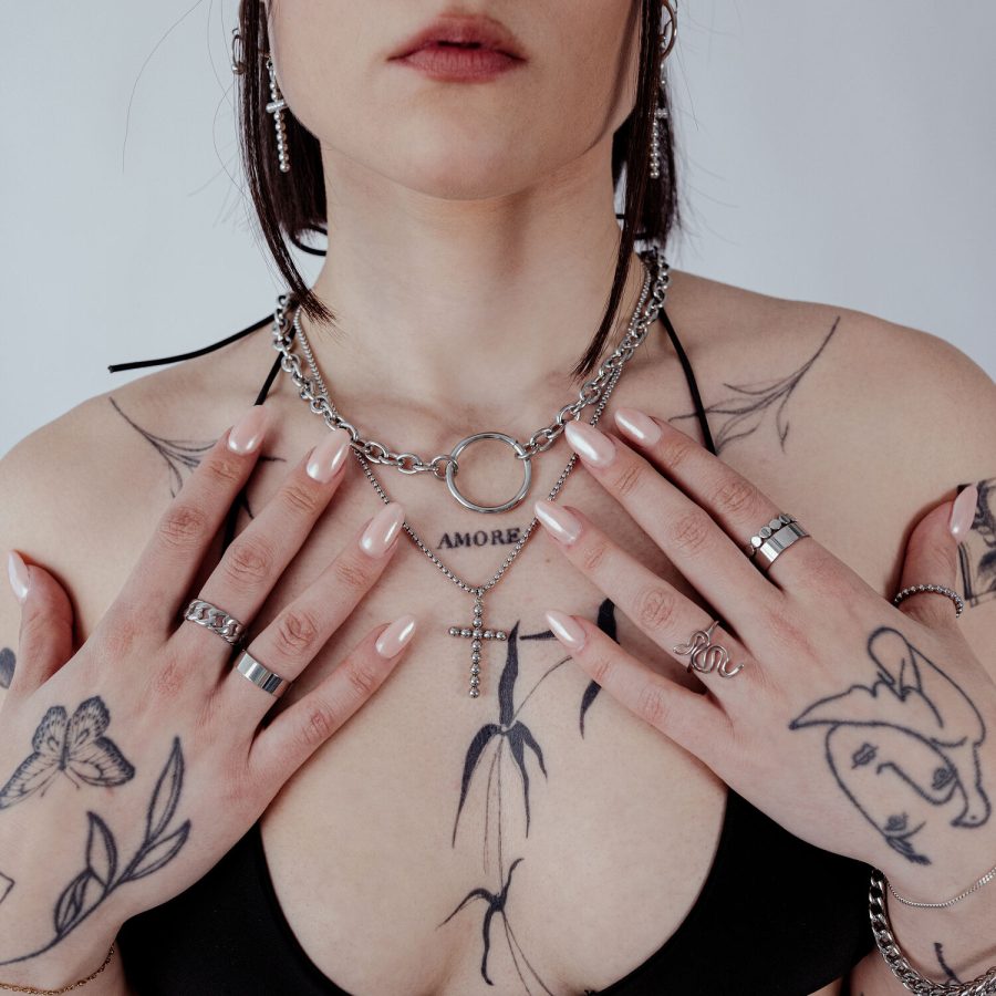 Frau mit Wildcat O Necklace aus Chirurgenstahl, Tattoos und Ringe