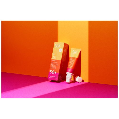 No Cosmetics Glowy Sunfluid in Tube vor orangem und pinkem Hintergrund