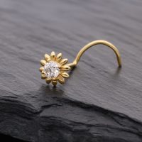 Goldener Nasenstecker in Sonnenblumenform mit klarem Kristall auf dunklem Hintergrund