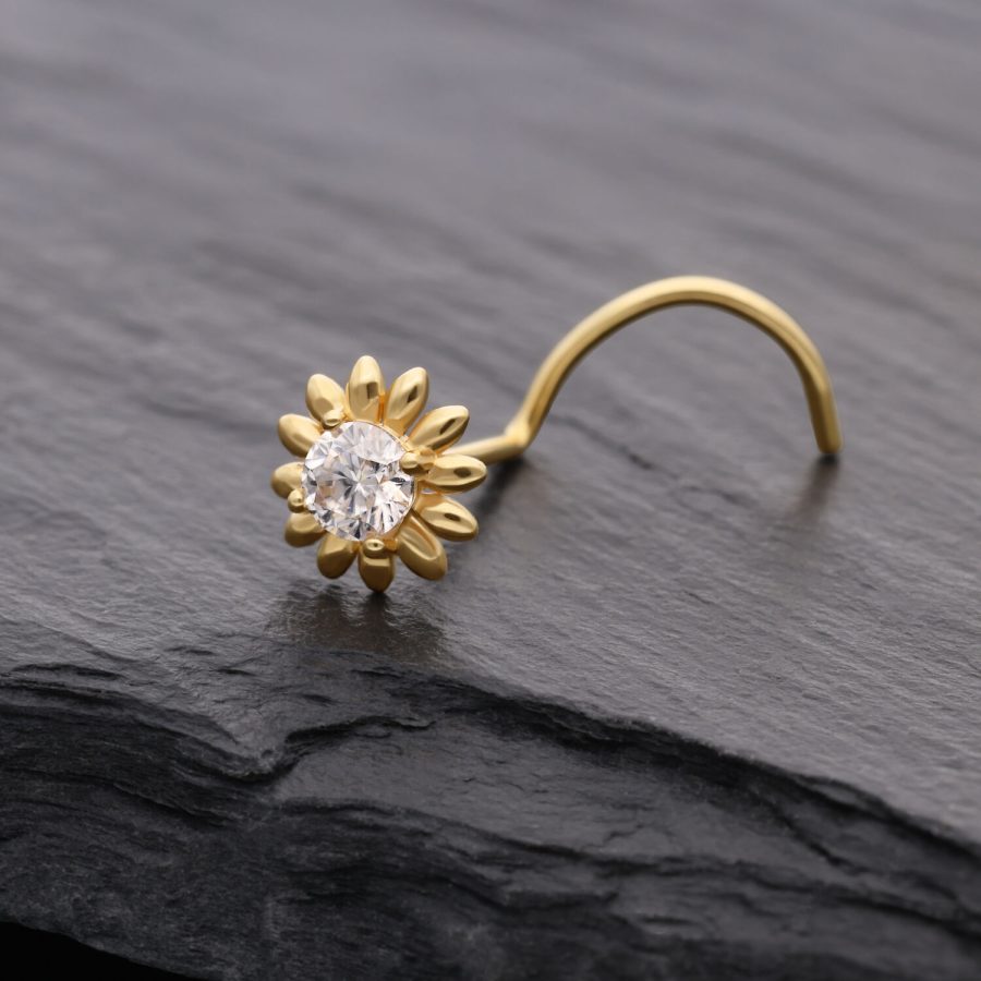 Goldener Nasenstecker in Sonnenblumenform mit klarem Kristall auf dunklem Hintergrund