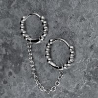 Silberne Doppel-Huggie-Ohrringe mit Kugeln und Kette auf grauem Hintergrund