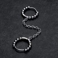 Silberne Double Huggie Ball Hoops mit Kettenverbindung auf dunklem Hintergrund