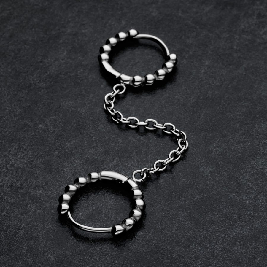 Silberne Double Huggie Ball Hoops mit Kettenverbindung auf dunklem Hintergrund