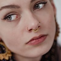 Frau mit goldenem Conch Ring und weißen Kristallen, Nahaufnahme