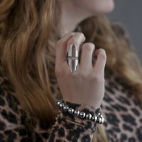Großer Fingerring mit Kreuzmuster aus Chirurgenstahl an einer Hand getragen