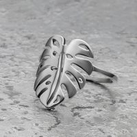 Silberner Monstera Blatt Ring aus Chirurgenstahl auf grauem Hintergrund