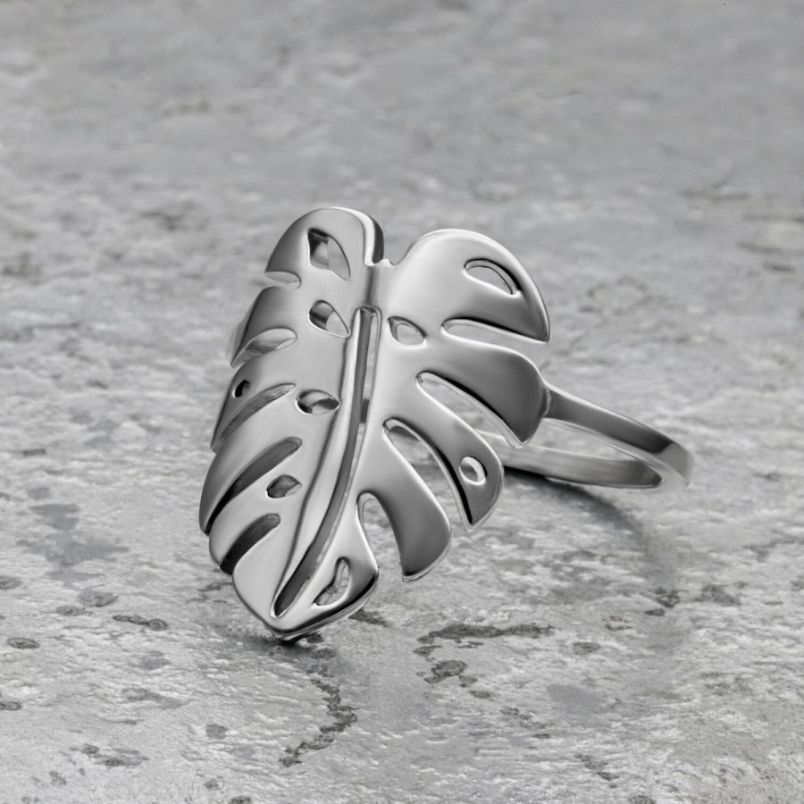 Silberner Monstera Blatt Ring aus Chirurgenstahl auf grauem Hintergrund