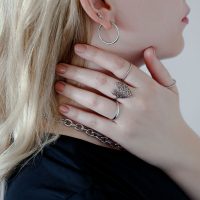 Silberner Lovely Leaf Ring an der Hand einer Frau, die Kette hält