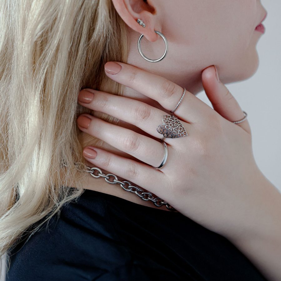 Silberner Lovely Leaf Ring an der Hand einer Frau, die Kette hält