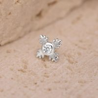 Silberner Push Fit Piercingaufsatz in Form eines Blattes mit klarem Kristall auf sandigem Hintergrund