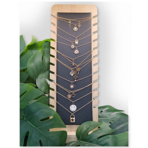 Schwarzes Display aus Kunstleder und Holz mit Ketten und Pflanzen im Hintergrund