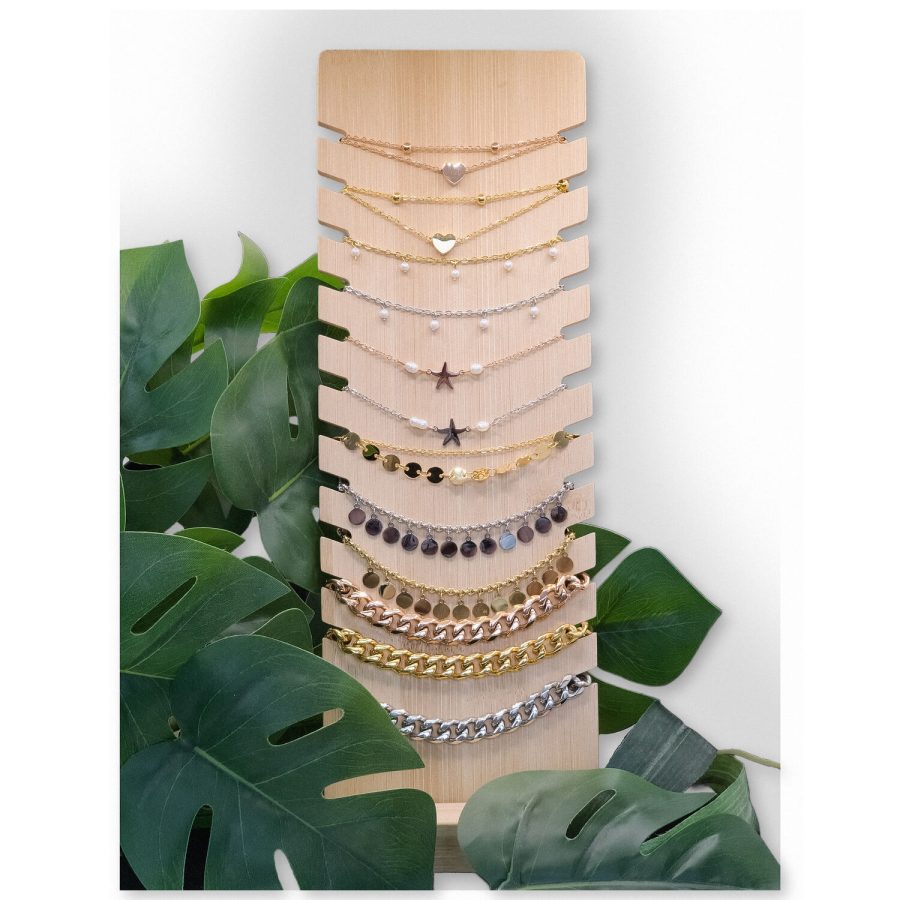 Holzdisplay mit schwarzen Kunstlederakzenten, umgeben von Pflanzen