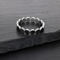 Silberner Ring aus Chirurgenstahl auf dunkler Steinoberfläche