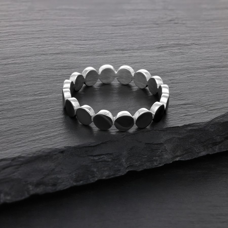Silberner Ring aus Chirurgenstahl auf dunkler Steinoberfläche