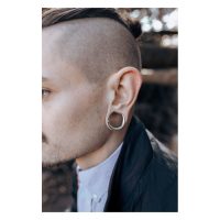 Mann mit silbernen Ear Saddles im Ohr vor unscharfem Hintergrund