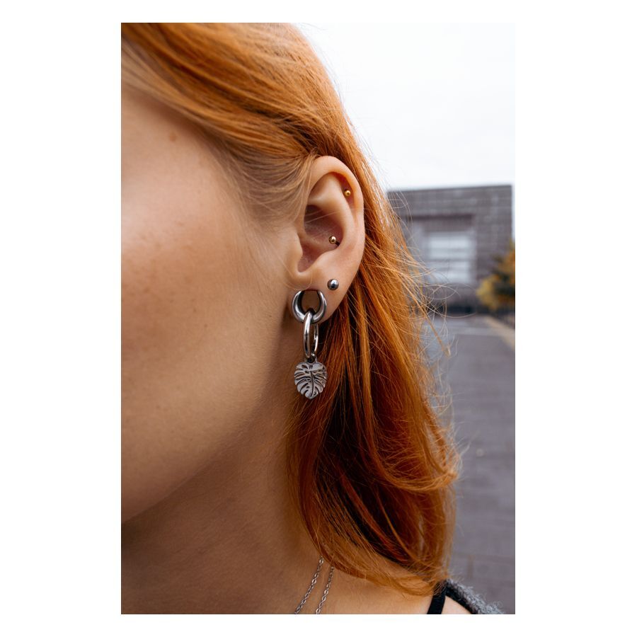 Schwarze Ear Saddles aus Chirurgenstahl mit Blatt-Anhänger an einem Ohr getragen