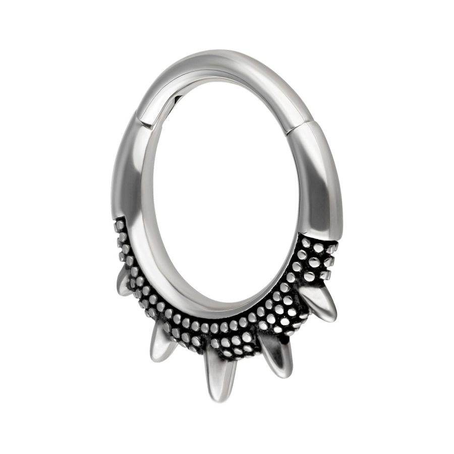 Silberner und schwarzer Piercingring mit stachelartigem Design auf weißem Hintergrund