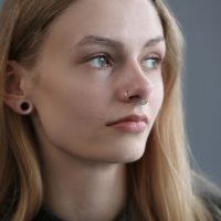 Frau mit silbernem Septum Clicker von Wildcat, grauer Hintergrund