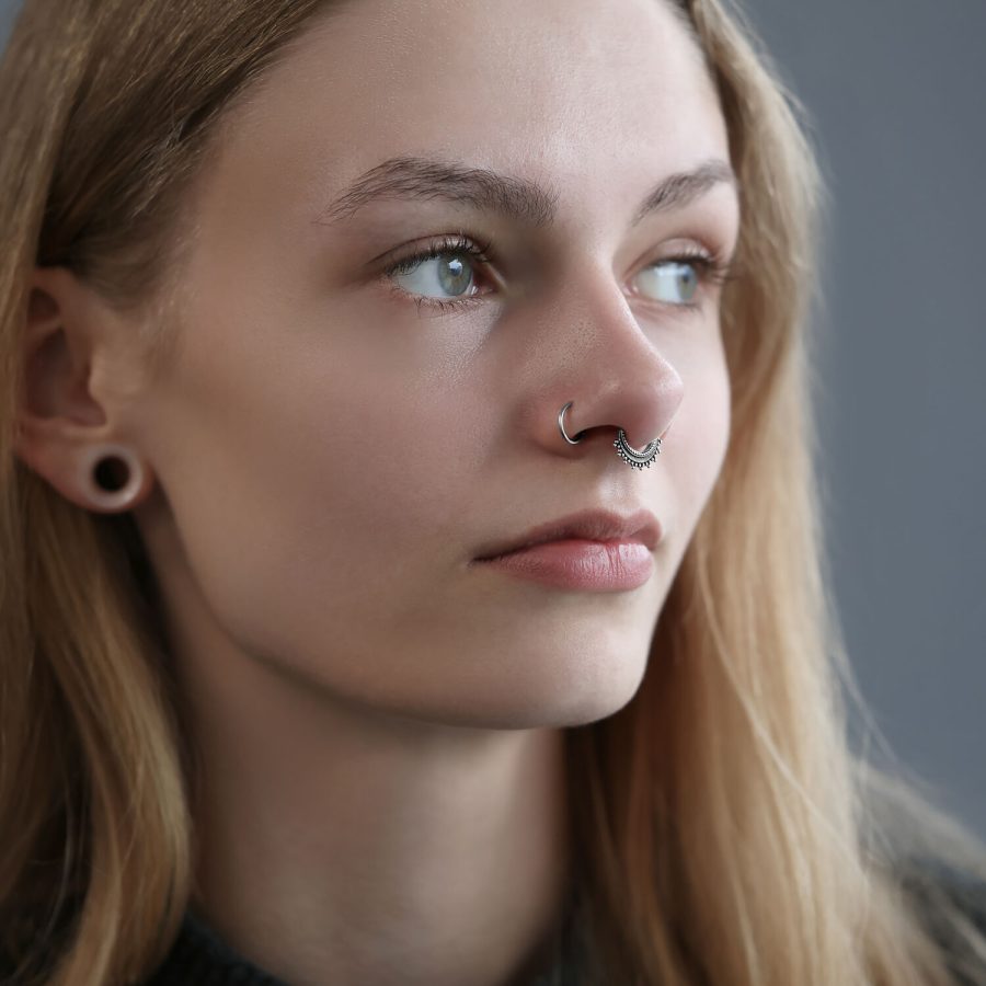Frau mit silbernem Septum Clicker von Wildcat, grauer Hintergrund