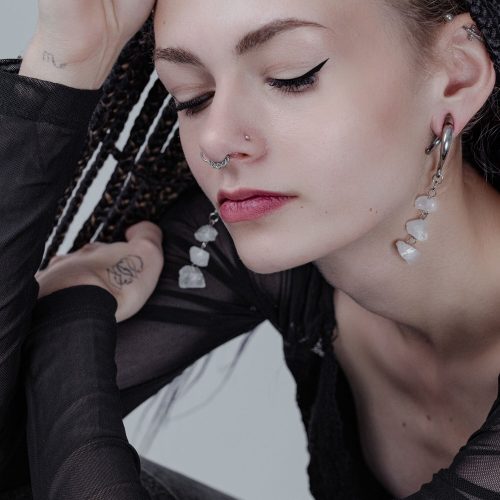 Frau mit Rocks Ohrgewichten aus Silber am Ohr und Nasenpiercing