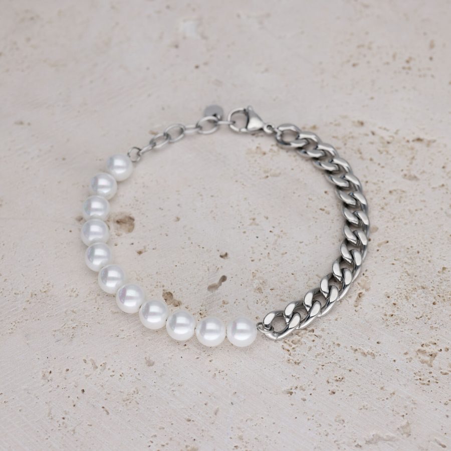 Armband mit weißen Perlen und silberner Kette auf hellem Stein