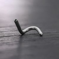 Silberner Titan-Push-Fit-Nasenstecker auf dunklem Hintergrund