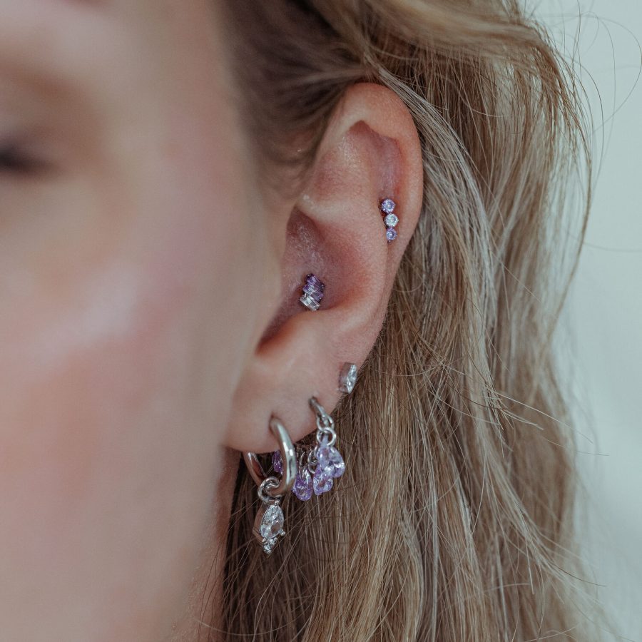 Ohr mit Piercing-Aufsatz in Lavendel und silbernem Metall, nahaufnahme