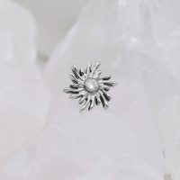 Silberner Sunburst Aufsatz mit kristallklarem Stein auf weißem Hintergrund