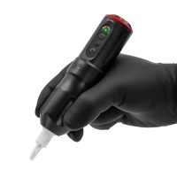 Schwarze FK Irons ONE Tattoomaschine mit Drop In Akku, gehalten in einer Hand