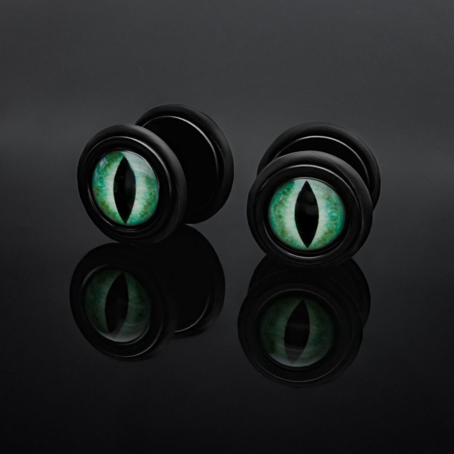 Schwarze Fake Plugs mit grünem Katzenauge auf schwarzem Hintergrund