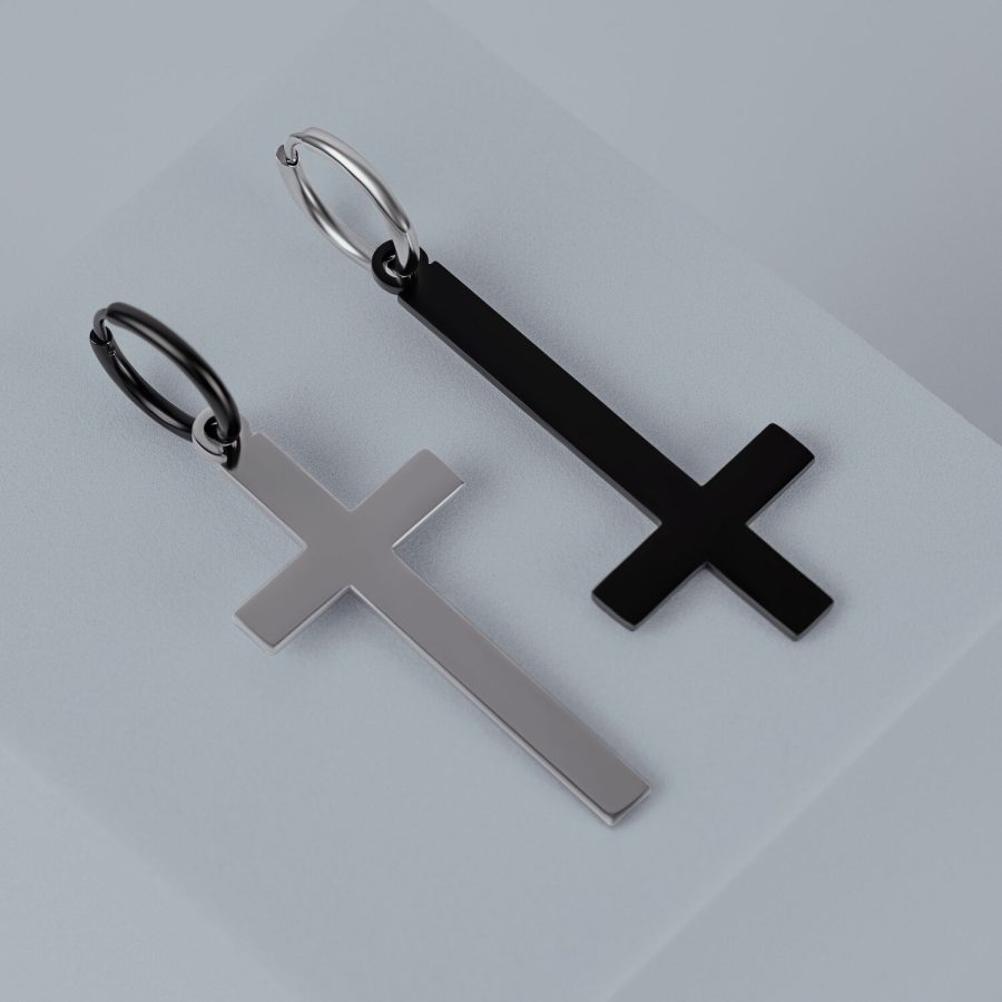 Zwei Kreuz-Ohrringe aus Chirurgenstahl in Gold und Schwarz auf grauem Hintergrund