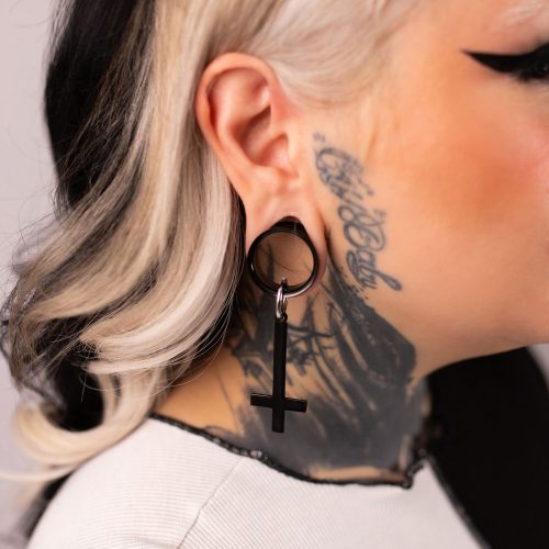 Schwarze Cross Hoops Ohrringe aus Chirurgenstahl 316L an einem Ohr mit Tattoo