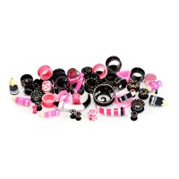 Verschiedene pink-schwarze Piercings auf weißem Hintergrund