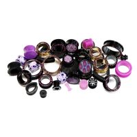 Verschiedene Piercings in Schwarz und Lila auf weißem Hintergrund