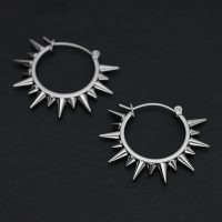 Zwei silberne Spiked Ohrringe aus Chirurgenstahl auf schwarzem Hintergrund