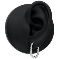 Silberne Oval Bubble Hoops am schwarzen Ohr auf neutralem Hintergrund
