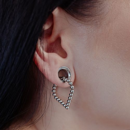 Silberne Bubble Polygon Hoops am Ohr einer Person