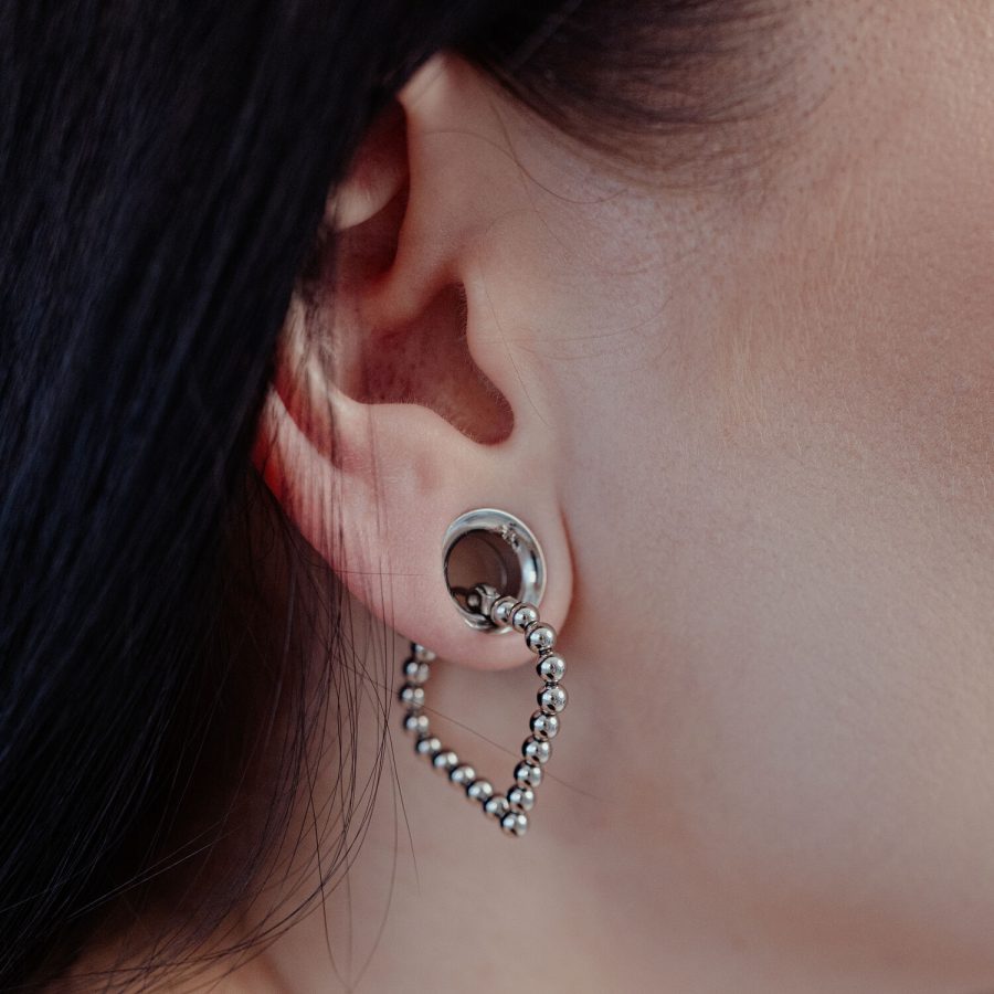Silberne Bubble Polygon Hoops am Ohr einer Person