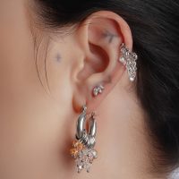 Silberne und goldene Glamour Hoops am Ohr einer Person, Nahaufnahme