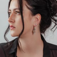 Frau mit glamourösen Creolen aus Silber und Gold, eleganter Look